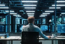 Technicien informatique supervisant des serveurs en salle d'infogérance haute sécurité