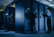 Ingénieur informatique inspectant des infrastructures serveurs en salle de data center moderne