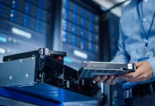 Technicien informatique remplaçant un disque dur de sauvegarde dans un data center